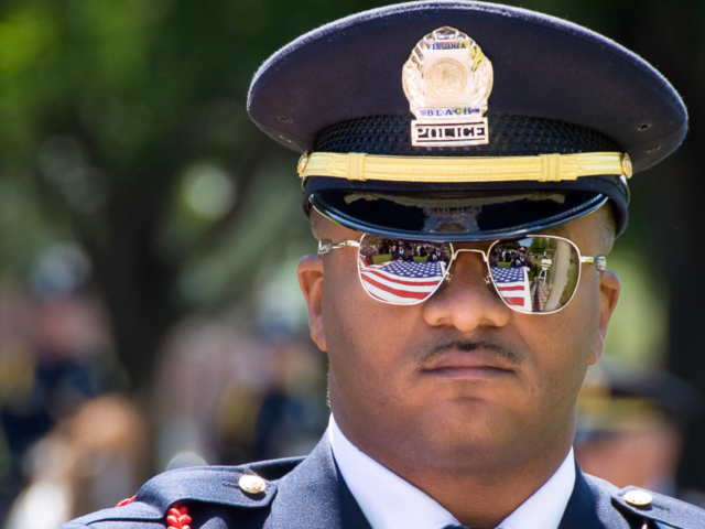 Police officer with U S flag reflected in sugnlasses Careers featured