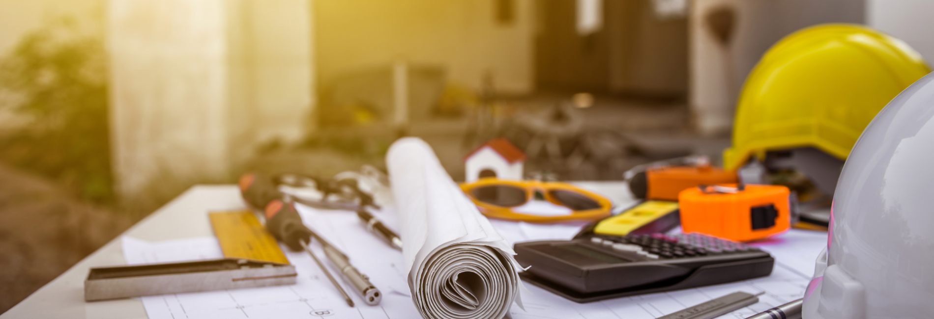 Table with site plans engineering tools and a hard hat Engineering and Construction