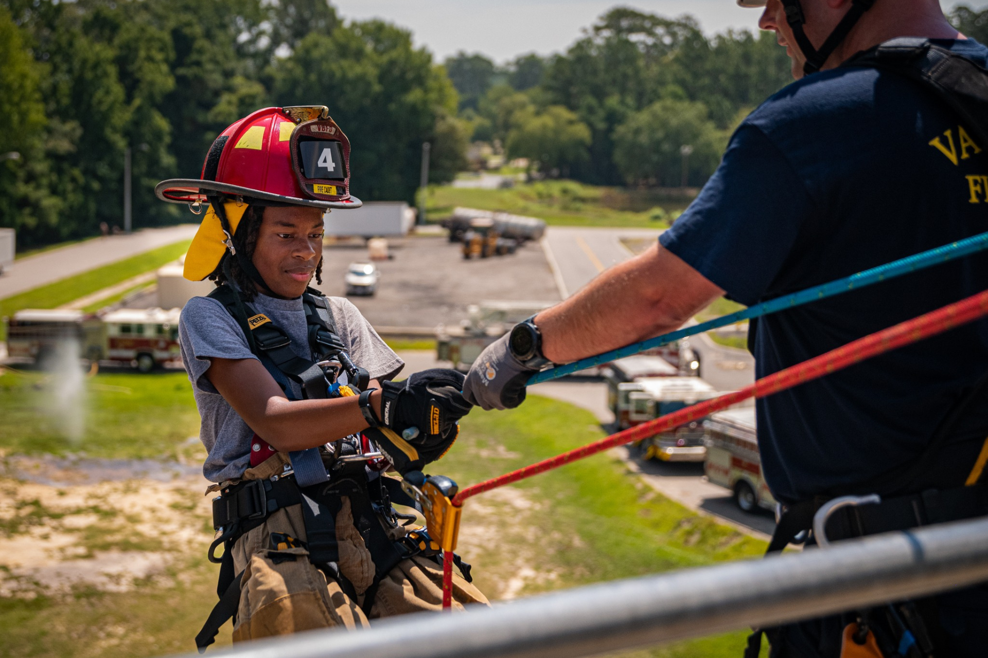 Fire cadet climbing over wall with ropes